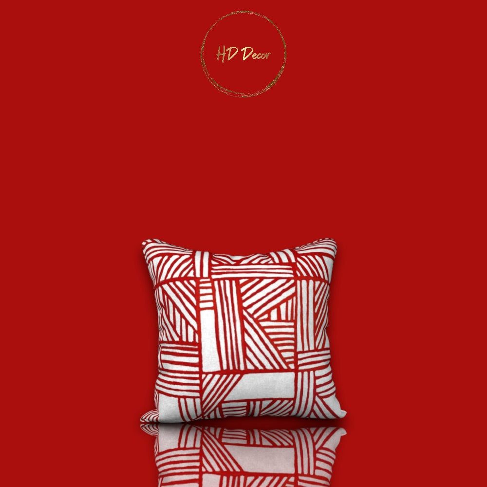 A square-shaped pillowcase with a bold red and white geometric pattern, presented against a red background with a reflective surface.