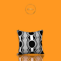 Decorative pillow with black and white pattern on an orange background