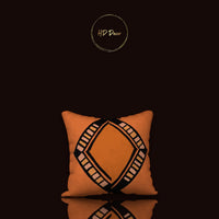 Orange pillow with black geometric pattern on a black background, featuring the brand 'HD Decor'.